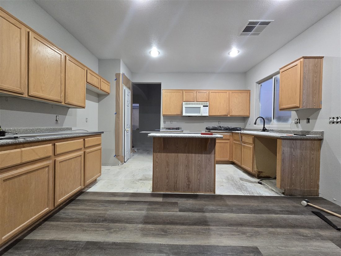 Grey LVP flooring installed in a Las Vegas kitchen with oak cabinets