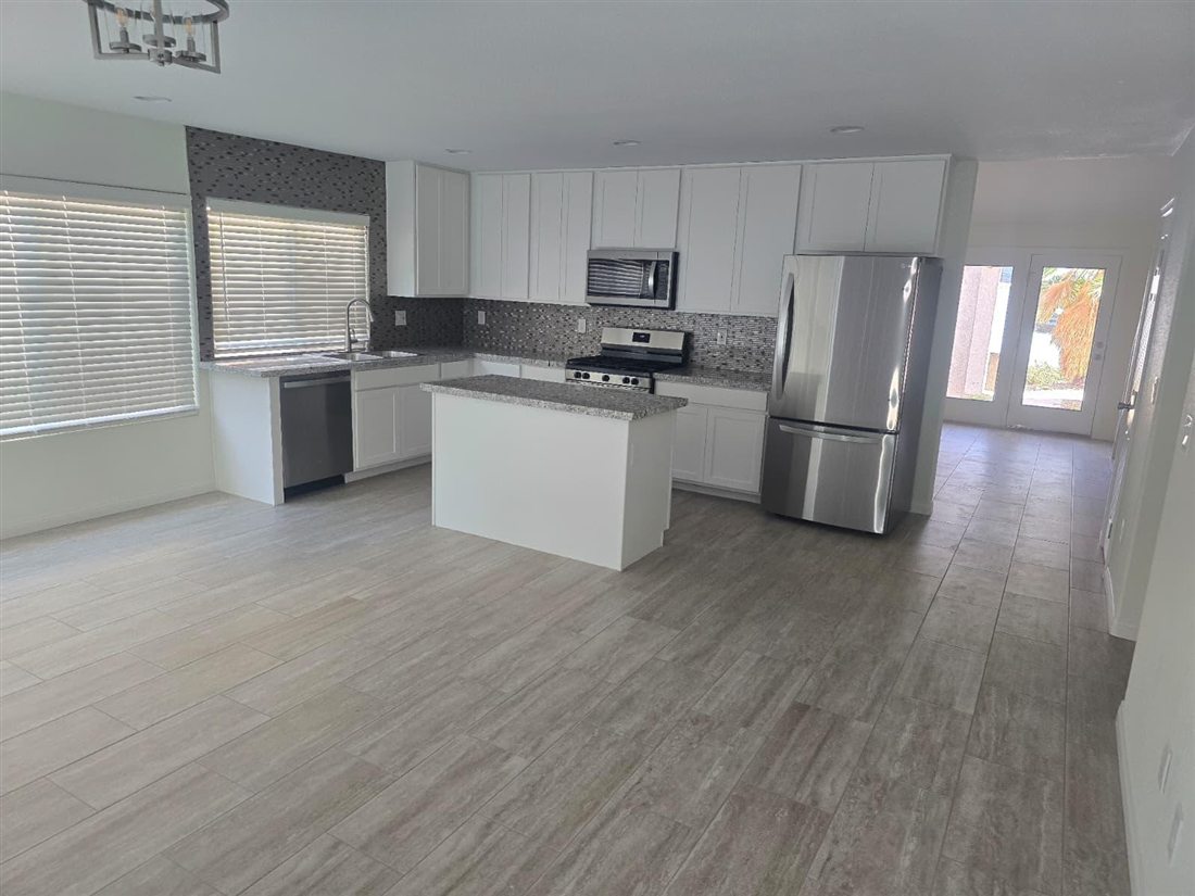 Light wood-look flooring in a remodeled white kitchen in Las Vegas