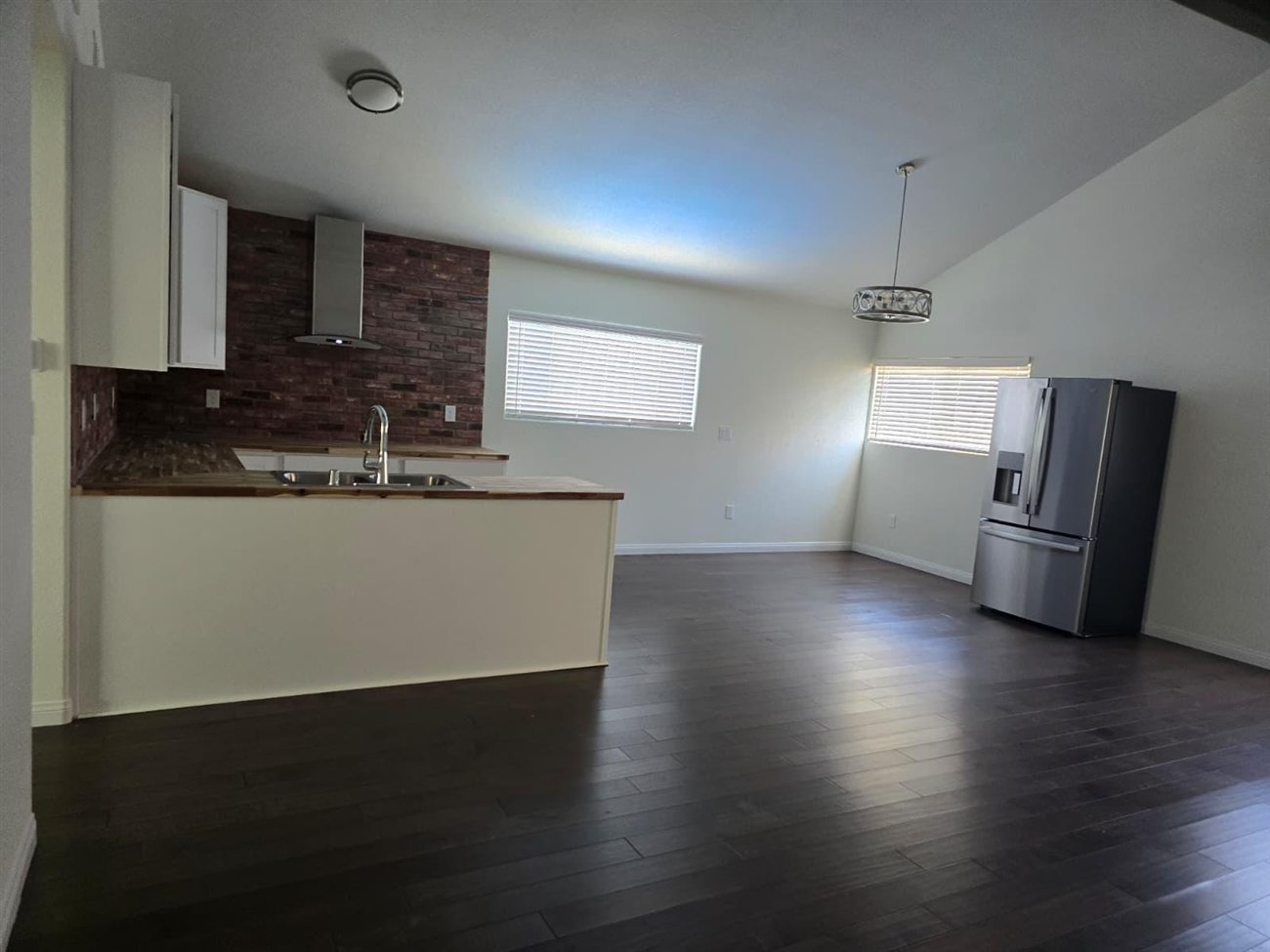 Dark hardwood flooring across an open kitchen and living room